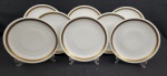 REAL. Oito pratos rasos em porcelana nacional, esmaltada na cor branca, decoração com frisos dourados e flores. Manufatura no verso. Med.: 25,5 cm diâm.