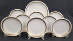 REAL. Conjunto para sobremesa em porcelana nacional, esmaltada na cor branca, decoração com frisos dourados e flores. Composto de prato de bolo e 8 pratos para sobremesa. Manufatura no verso. Med.: 28 cm e 19 cm diâm.