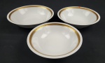 REAL. Três saladeiras em porcelana nacional, esmaltada na cor branca, decoração com frisos dourados e flores. Manufatura no verso. Med.: 6 x 23 cm e 6 x 24 cm e 6 x 26 cm. uma com bicado.