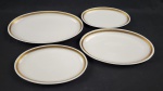 REAL. Quatro travessas ovais em porcelana nacional, esmaltada na cor branca, decoração com frisos dourados e flores. Manufatura no verso. Med.: 26 x 17 cm e 24 x 40cm.