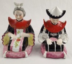 Par de serre-livres em porcelana decorativa figuras orientais sentadas com vestes policromadas, c. 1920 - 1950. Figuras modeladas em porcelana esmaltada, cada um com trajes ricos em padrões florais e arabescos. Medida 16 x 12 x 12 cm.