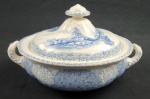 ROYAL DOULTON, Inglaterra. Terrina com tampa em faiança inglesa, ricamente decorada em azul sobre fundo branco, com paisagens, personagens, flores e folhagens. Manufatura no verso. Med.: 16 x 27 x 23cm. Manchas e craquelê.
