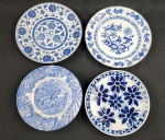 Quatro pratos decorativo em porcelana esmaltados nas cores azul e branco, de procedências diversas. Medindo: 23 cm e 26 cm. Sendo um deles fundo.