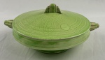 GRINDLEY, Inglaterra. Terrina em faiança inglesa na cor verde, de desenho característico Art Déco, com decoração concêntrica em relevo. Manufatura no verso. Apresenta craquelê. Med.: 14 x 27 x 22 cm. Apresentam manchas e craquele.