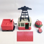 Brinquedo antigo: Teleférico Lehmann Rigi 900 com gôndola, fabricado na Alemanha pela empresa Lehmann. Componentes: O conjunto inclui a gôndola do teleférico, uma estação de operação manual com manivela e um carretel de cabo. Colecionismo: É um item popular entre colecionadores de brinquedos antigos e entusiastas de modelismo ferroviário na escala G