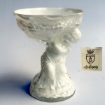 SEGUSO-CÁDORO - Floreira em vidro de Murano branco leitoso com figura de querubim com cesta de uvas em relevo. Med 13,5 x 10 cm. 