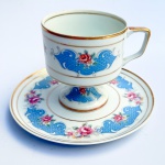 Belíssima xícara de coleção para chá, possui pé alto e decoração floral em azul e rosa com filetes dourados. Med xícara 9,5x11cm pires 17cm diâmetro. 