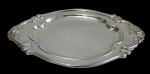 Bandeja oval em metal espessurado a prata, cinzelada com motivo floral. Medindo: 37 x 24 cm.