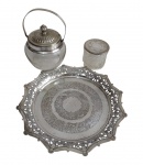Três peças produzidas em metal espessurado a prata sendo uma bandeja, um pequeno pote com tampa e açucareiro. Medindo: 27 x 2 / 7 x 7 / 16 x 12 cm .
