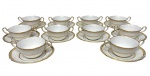 Dez xícaras consumes com seus respectivos pires, produzidos em porcelana na cor branca e filetes dourados. Medidas: consume; 14,5 x 10 x 5,5 cm. Pratinho; 15,5 cm de diâmetro.