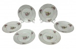 Seis pratos para sobremesa em porcelana na cor branca, esmaltado e policromado com flores e filete dourado. Medindo: 18 cm.