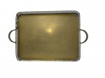 Bandeja para servir em metal dourado, apoiada sobre quatro pés, bordas laterais fenestradas e alças laterais.Medindo: 7 x 54 x 35 cm.