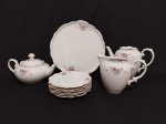 Antigo conjunto para sobremesa em porcelana RENNER,  decoração floral e borda ondulada com friso dourado, contendo 1 prato de bolo medindo 28 cm de diâmetro e 6 pratinhos com 18 cm, 1 bule de café, 1 bule de chá e 1 leiteira. O bule de café está sem tampa.