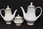 Noritake, coleção Polonaise, porcelana japonesa Policromada Oriental com bordas e flores ornada a ouro, com tendo um bule de chá medindo 18 X 25 cm, um bule de café medindo 21 X 21 cm e um açucareiro medindo 12cm.