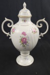 Vaso ou ânfora com tampa em  porcelana húngara branca, da marca HOLLÓHAZI padrão HAJNALKA, com desenho floral policromado (rosas) com acabamentos em filetes de ouro.  Feito na Hungria. Apresenta restauro em uma alça, medidas 43x31cm.