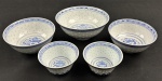 China. Cinco tigelas em porcelana chinesa, com decoração em policromia azul sobre fundo branco, apresentando motivo central de dragão e borda ornamentada com frisos geométricos em estilo oriental. Padrão Grão de Arroz. Medida: 6 x 10 cm à 8 x 18 cm.