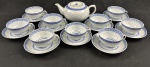 China. Conjunto para chá em porcelana chinesa, com decoração em policromia azul sobre fundo branco, apresentando motivo central de dragão e borda ornamentada com frisos geométricos em estilo oriental. Padrão Grão de Arroz. Composto de bule e e 9 xicaras. Bule mede:.10 x 22 x 15 cm.