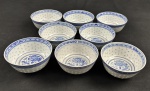 China. Oito tigelas em porcelana chinesa, com decoração em policromia azul sobre fundo branco, apresentando motivo central de dragão e borda ornamentada com frisos geométricos em estilo oriental. Padrão Grão de Arroz. Medindo: 6 x 11,5 cm.