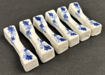 Seis descansos em porcelana  com decoração em policromia azul sobre fundo branco, apresentando motivo floral. Medindo: 6,5 cm.
