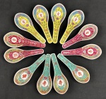 China. Doze colheres em porcelana esmaltada e policromada, nas cores Verde, amarelo e vermelho. decorada com motivos orientais. Medindo: 12 cm.
