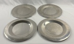 Conjunto com 04 sousplats produzidos em metal prateado, de formato circular, com borda levemente elevada e acabamento polido. Medindo 35 cm de diâmetro, cada.