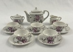 Miniatura. Conjunto de chá em  porcelana japonesa, ricamente decorado em policromia com motivos florais. Composto por 1 bule, 1 açucareiro, 1 leiteira e 5  xícaras com 9 pires. Marcado Made in Japan. Bule; 10 x 13 cm.