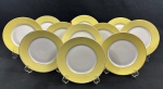 Mauá. Onze pratos para sobremesa em porcelana esmaltada com borda amarela sobre fundo banco. Filetes em ouro. Manufatura no verso. Medindo: 19 cm. Um com lasca.