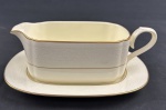 RC Bone China by Noritake, Japan. Molheira com presentoir em porcelana esmaltada, em tom marfim, com bordas decoradas em relevo com arabescos e delicado friso em ouro na borda, com acabamento refinado e decoração em baixo-relevo. Medidas; 7 x 20 x 8,5 cm e 20 x 14,5 cm.