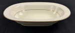 RC Bone China by Noritake, Japan. Saladeira em porcelana esmaltada, em tom marfim, com bordas decoradas em relevo com arabescos e delicado friso em ouro na borda, com acabamento refinado e decoração em baixo-relevo. Medidas; 6 x 26 x 19,5 cm.