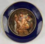 Prato decorativo em porcelana, manufatura tcheca, (Fine Decoration). Medalhão central com pintura policromada reproduzindo a obra A Negação de São Pedro, de Gerard van Honthorst, destacando o uso do claro-escuro com iluminação à vela. Aba larga em azul cobalto (Bleu de Roi), com filetes e debrum em ouro brunido. Medindo: 26 cm.