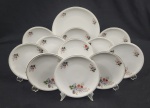 Real. Conjunto para sobremesa, composto de prato de bolo e 11 pratos para sobremesa em porcelana esmaltada, decorado com delicados motivos florais policromados sobre fundo branco e friso dourado nas bordas. Manufatura no verso. Medindo: 28 cm e 19 cm.