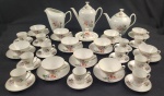 Real. Serviço para chá e café em porcelana esmaltada, decorado com delicados motivos florais policromados sobre fundo branco e friso dourado nas bordas. Composto de bule de chá, bule de café, leiteira, manteigueira, 11 xícaras de chá com seus pires e 11 xícaras de café com seus pires. Manufatura no verso. Medindo:.  bule; 22,5 x 22 cm, bule; 19 x 23 cm, leiteira; 16 x 18 cm, manteigueira; 9 x 16 cm.