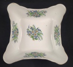 Real. Saladeira em porcelana nacional com decoração policroma com flores e folhagens sobre fundo branco, borda com friso a ouro (desgastes na douração). Marcada. 6,5 x 21 x 21 cm.