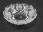 Cinzeiro em cristal incolor com borda recortada e corpo decorado com elementos florais em relevo e frisos lapidados, fundo circular liso, medindo 6 cm de altura por 20 cm de diâmetro.