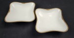 Hutschenreuther Hohenberg, Alemanha. Duas saladeiras em porcelana alemã esmaltada na cor branca, borda com rendilhado em preto sobre fundo dourado. Manufatura ao verso. Medindo: 6x21x21 cm.