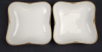 Hutschenreuther Hohenberg, Alemanha. Duas saladeiras em porcelana alemã esmaltada na cor branca, borda com rendilhado em preto sobre fundo dourado. Manufatura ao verso. Medindo: 17 x 17 cm.