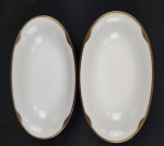 Hutschenreuther Hohenberg, Alemanha. Duas espinheiras em porcelana alemã esmaltada na cor branca, borda com rendilhado em preto sobre fundo dourado. Manufatura ao verso. Medindo: 4x14x25 cm.