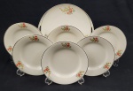 Vista Alegre, Portugal. Conjunto de bolo em porcelana portuguesa, borda decorada com flores e folhagens policromadas com frisos a folha de ouro, marca da manufatura na base. Composto por 1 prato para bolo (25 cm) e 6 pratos para sobremesa (17 cm).