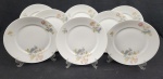 Rosenthal, Bavaria. Oito pratos rasos em porcelana alemã, esmaltada com decoração floral policromada em tons pasteis. Manufatura no verso. Medindo: 25 cm.