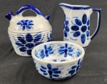 Monte Sião - Três peças em porcelana esmaltada, decoração com flores azuis sobre superfície branca.  Medindo: Jarra ( 16x14), Bule (15x14x15), bowl (6x13).