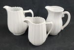 Conjunto com três jarras em porcelana, para água e sucos na cor branca. Medidas da maior 20 x 17 cm e menor 17 x 15 cm. Restauro em uma alça.