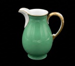 ERRATA: KGL.PRIV.TETTAU- Leiteira em porcelana alemã na coloração verde com frisos e alça dourada. Marcada no verso. Med.: 13 x 10cm.