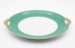 ERRATA: KGL.PRIV.TETTAU - Prato para bolo em porcelana alemã na coloração verde com frisos, pega das alças vazadas e douradas. Marcada no verso. Med.: 28,5cm.