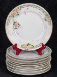 Nove pratos em porcelana branca japonesa, com decoração de flores, folhas e arabescos. Med.: 19 cm.