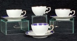 REAL - Nove xicaras para café e três pires  em porcelana nacional com base na cor branca. Borda azul cobalto acabamento arabescos na cor dourada.