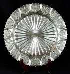 ART PRATA - Bandeja redonda em metal prateado com bordas ricamente cinzeladas e vazadas. Diâmetro: 34 cm.