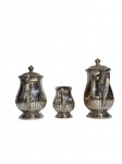 Conjunto de três bules espessurados a prata. Med. 22cm de altura x 9cm de diâmetro (chocolateria); 19cm de altura x 9cm de diâmetro (chaleira); 11cm de altura x 6,5cm (leiteira).