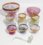 Conjunto dos anos 1950 em vidro iridescente com cores diversas e faixas douradas. Obs: contém 1 poncheira, 1 fruteira e 6 taças.