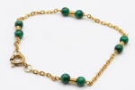 Pulseira de ouro 18k com contas esféricas de malaquitas intercaladas.17 cm. Peso total bruto: 2.9g.