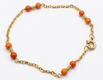 Pulseira de ouro 18k com contas esféricas de coral intercaladas.17 cm. Peso total bruto: 2.45g.